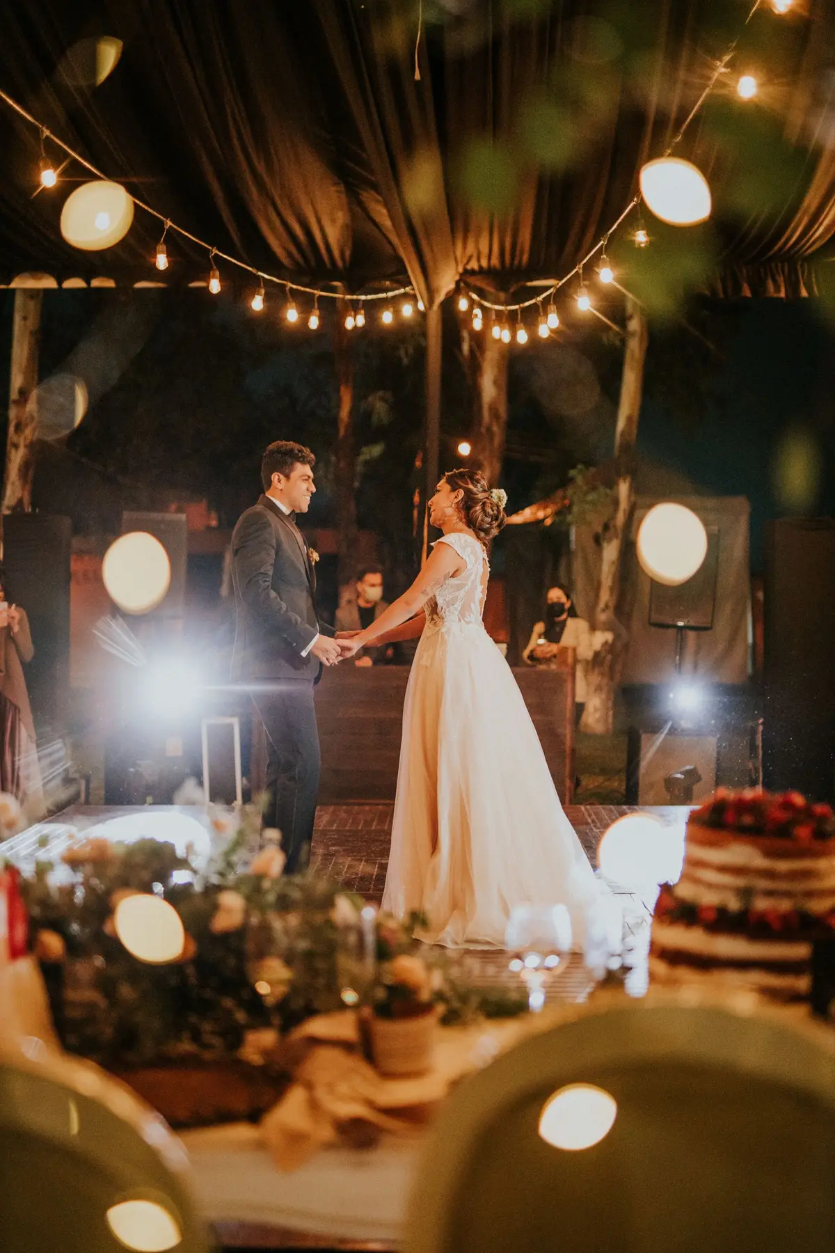 Mariés sous les guirlandes lumineuses lors d'une réception de mariage dans la région lilloise